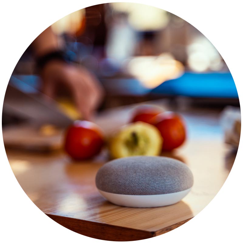 Smart speaker with man cutting vegetables in the background